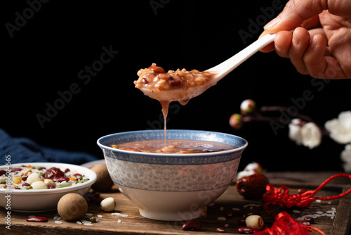  red rice porridge in a bowl. traditional food Laba porridge on table.