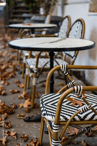 Street cafe tables covered with fallen leaves