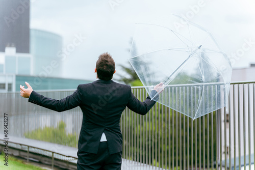 雨の日に傘をさす外国人ビジネスマン（梅雨・台風・雨上がり・異常気象） 