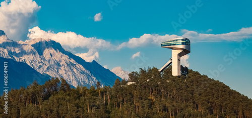 Alpine summer view with the famous Berg Isel Ski Jump Tower and the Nordkette mountains in the background near Innsbruck, Austria