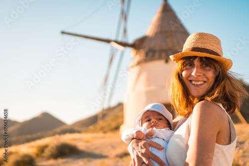 Mother with a baby in arms visiting traditional windmills