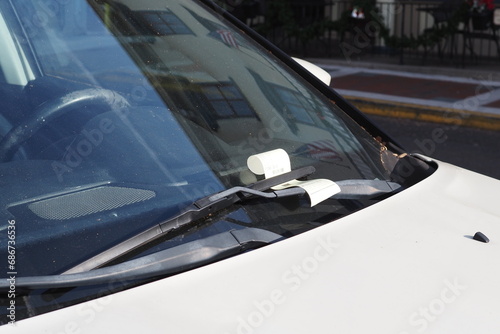 Their is a parking ticket under the windshield wiper.