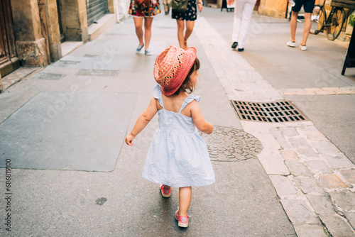 France, Aix-en-Provence, toddler girl walking down the streets of the city center