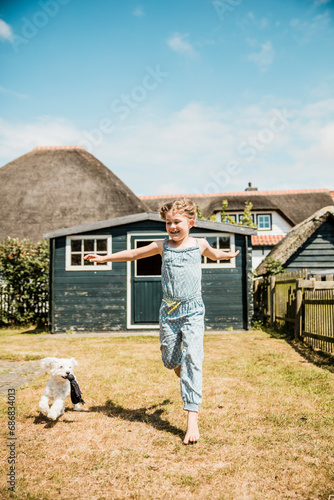 Girl running with dog in garden