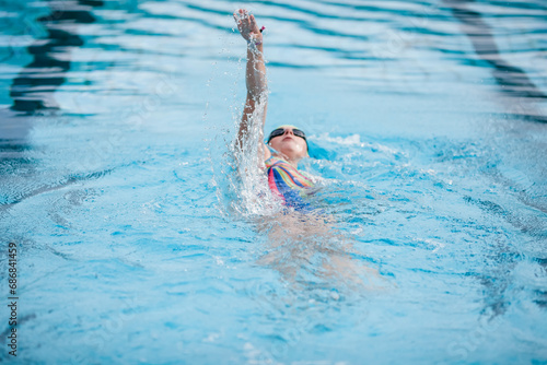 Young woman swimming in swimming pool, backstroke