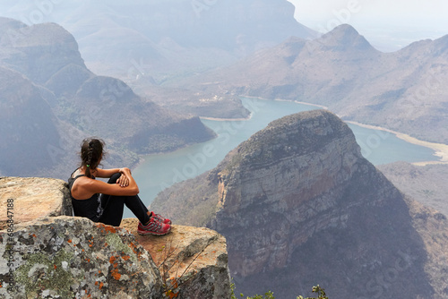 Woman sitting on a rock with beautiful landscape as background, Blyde River Canyon, South Africa