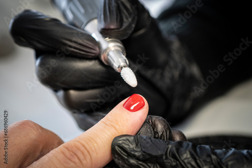 Man manicure. The process of coloring nails on men's fingers in a beauty salon. Manicurist girl gives a guy a manicure. close up nail sawing