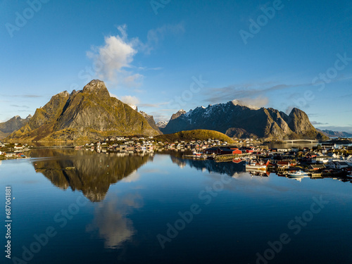 aerial view over reine nordic norwegian village surrounded with moountains with reflections on lofoten islands