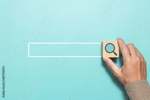 A man putting wood cube with magnifying glass icon that represents searching data information networking. Concept for network web and technology