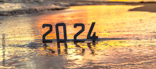 Bonne année 2024 : concept de nouvelle année 2024 avec un lever de soleil sur la plage et les chiffres 2024 en reflet dans la mer. 
