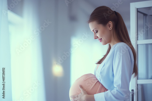 Happy joyful pregnant woman in a maternity modern hospital, big belly, twins. Gynecological services for pregnant women, pregnancy planning center, medical services.