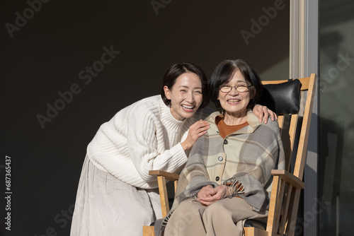 娘と母の高齢者介護の秋冬イメージ 仲良く会話するカメラ目線の親子のクローズアップ 左にコピースペースあり