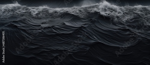 Bird's-eye view of waves on black Icelandic beach.