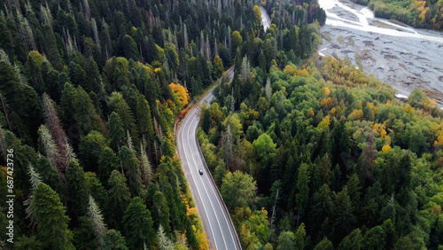 a road in the mountains in an autumn multicolored forest shot from above on a copter