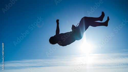 silhouette of a guy doing backflip in sunset