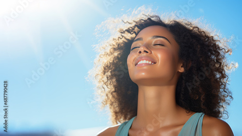 A African woman breathes calmly looking up isolated on clear blue sky