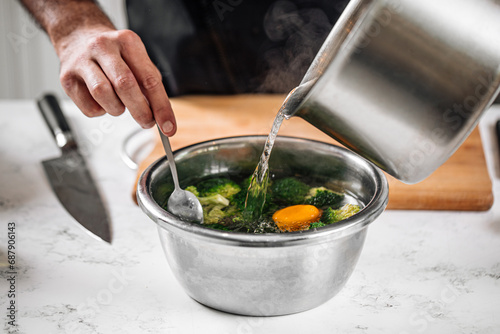 Chef blanching broccoli in a hot water with lemon