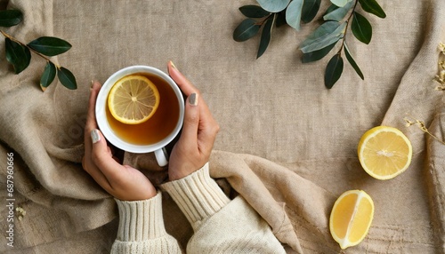 female hands hold cup of tea with lemon on linen beige cloth background copy space woman with cup of tea cozy atmosphere aesthetic minimal style autumn and winter theme