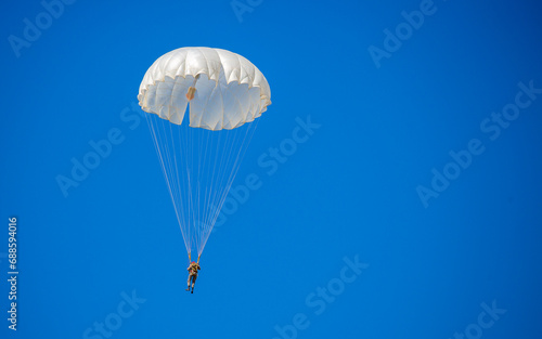 Skydiving. Flying parachutists against the background of the blue sky and mountains. Extreme sport and entertainment.