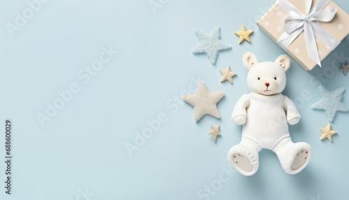 Baby accessories concept top view photo of gift box teether knitted bunny rattle toy and stars on isolated pastel blue background with empty space
