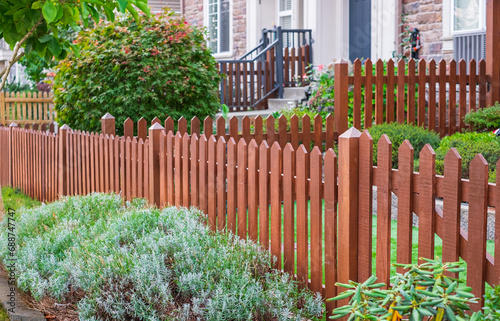 Nice wooden fence around house. Wooden fence with green lawn. Entrance gate. Street photo