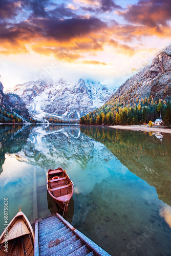 Magical beautiful autumn landscape with boats on the lake on Fanes-Sennes-Braies natural park in the Dolomites Alps, Italy at sunset. ( inner peace, harmony - concept)