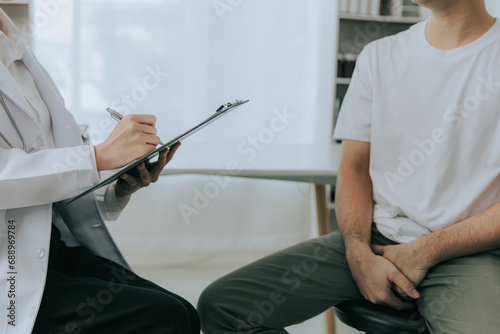 A doctor is counseling a young male patient about prostate cancer and venereal disease, including male sexual dysfunction. Prostate cancer concept