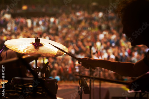 Drummer, music and crowd at stage, concert or musician in performance at festival or event with fans. Playing, rock or man on drums in a metal band with audience listening to beat, sound or show