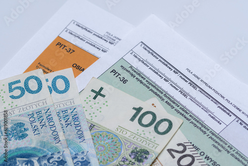 Polskie banknoty leżą na formularzach podatkowych pi37 pit28 cit