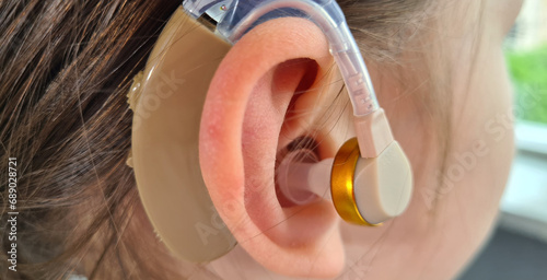 Hearing aid of child and girl suggests hearing aid