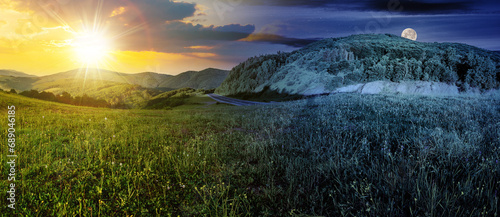mountainous landscape with asphalt road winding through the valley with sun and moon on the sky. day and night time change concept. panorama of countryside scenery in morning light at summer solstice