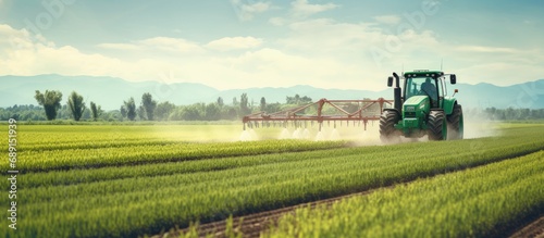 Farmer fertilizing green field with tractor Copy space image Place for adding text or design