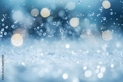 Cold snow falling background. Water drops and white ice blur bokeh. Sparkling blue background.