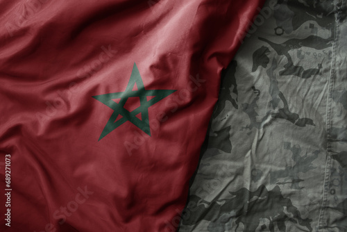 waving flag of morocco on the old khaki texture background. military concept.