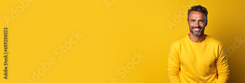 Handsome adult man with beard wearing casual sweater sweater standing on isolated yellow background smiling amazed laughing with surprised expression. Excited face human emotions concept. Copy paste