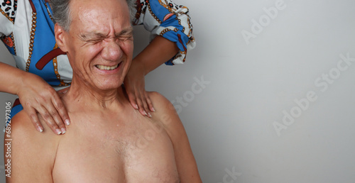 Older Mature Man having a massage on his upper back and neck for pain relief 