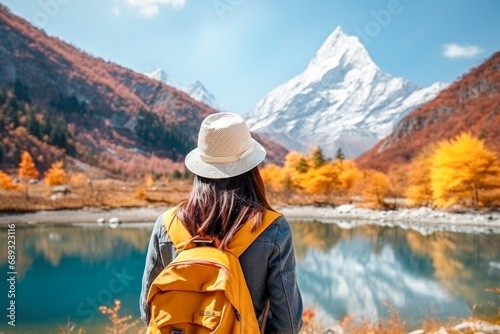 Woman hiker with backpack on the background of mountains and lake.