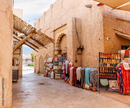 Shop with souvenirs and national dresses, scarves and fabrics in the reconstructed old part of the Dubai city - Al-Bastakiya quarter in the Dubai city, United Arab Emirates