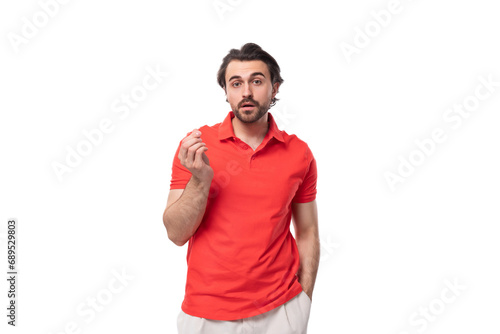 young handsome european brunette man with a beard dressed in a red t-shirt with a mockup actively gesticulates