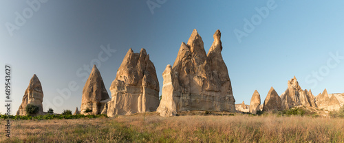 panorama view over Fairy Chimneys, special volcanic rock formation lit by evening lights at Red Valley, Göreme, Cappadocia, Turkey