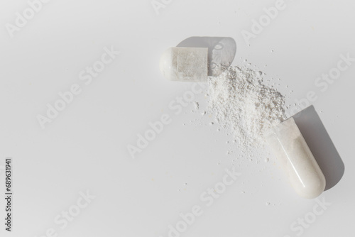 The white capsule was opened and a white powder poured out of it. Medicines, vitamins.Copy space