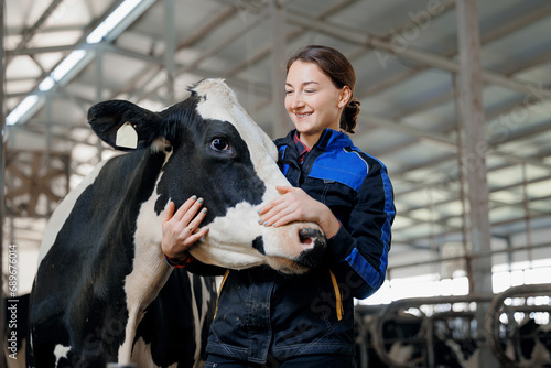 Happy young woman farm worker hugging cow as sign of concern for animal health care. Concept agriculture cattle livestock farming industry