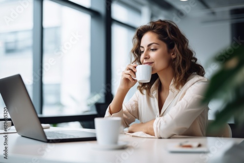 female drinking coffee at desk
