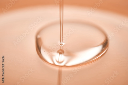 A juicy drop of gel on a Peach Fuzz background.