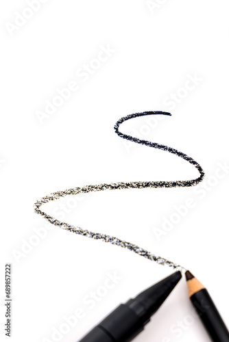 Defocused business or beauty vertical banner with textured line from two eyeliner pencils or kajal isolated on the white background