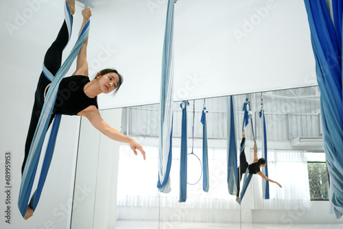 Asian beautiful woman doing aerial hoop practice in ring at studio, woman perform dances using a ring in the dance