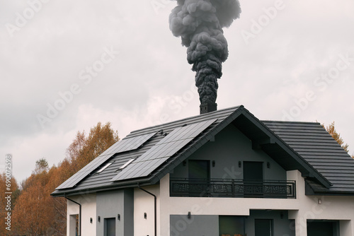 A house with a chimney emits black smoke in the cold air, causing environmental pollution