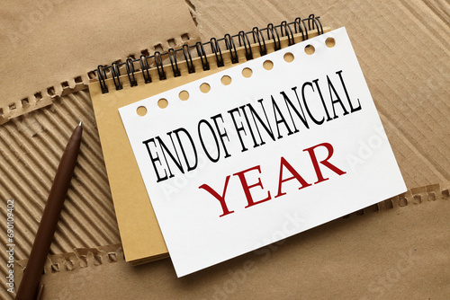 End of Financial Year text. craft notebook on a craft background. text on white page