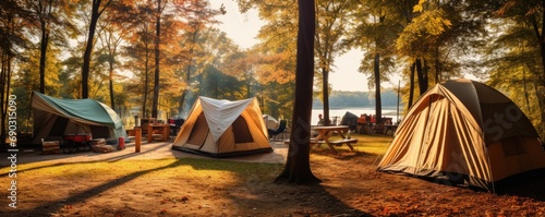 Tents at amazing camping site in the forest near the lake. Camping theme.