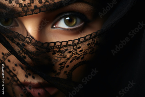 Beautiful arabic woman's face hidden behind the curtain of a veil, expressive eyes